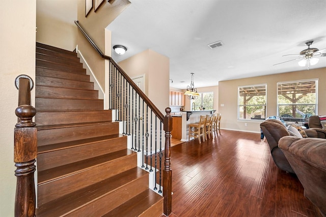 staircase featuring ceiling fan and wood-type flooring