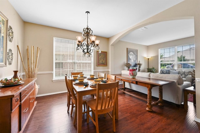 dining room with dark hardwood / wood-style flooring and a notable chandelier