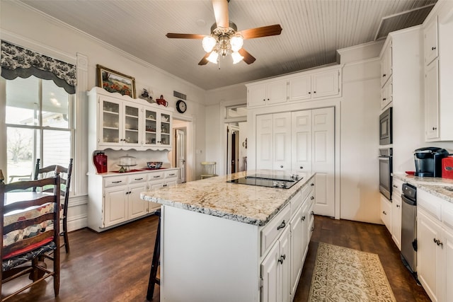 kitchen featuring light stone counters, a kitchen island, black appliances, dark hardwood / wood-style floors, and white cabinetry