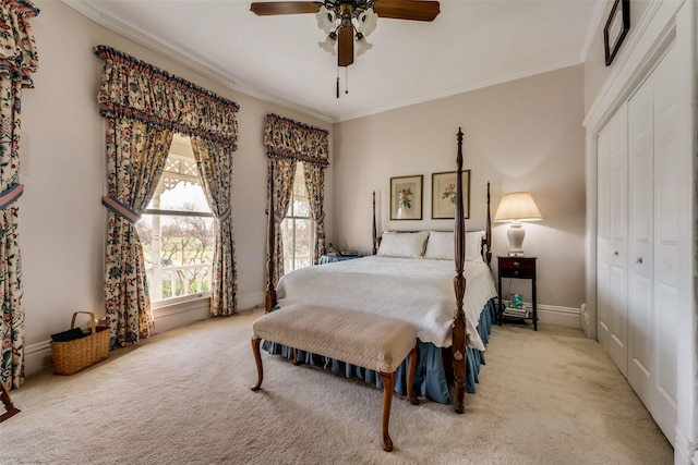 bedroom with ceiling fan, ornamental molding, light carpet, and a closet