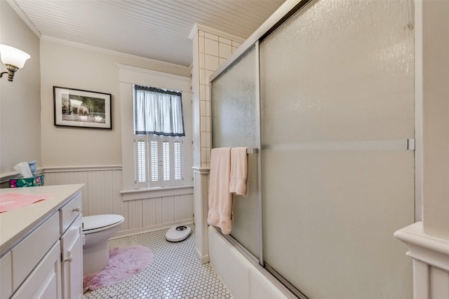 full bathroom featuring vanity, toilet, ornamental molding, and enclosed tub / shower combo