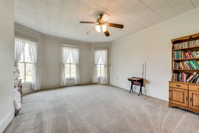 spare room featuring ceiling fan, light colored carpet, and ornamental molding