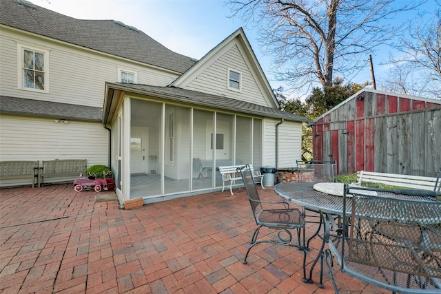 rear view of house featuring a sunroom and a patio area