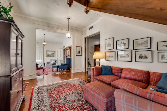 living room with crown molding, dark wood-type flooring, a chandelier, and vaulted ceiling