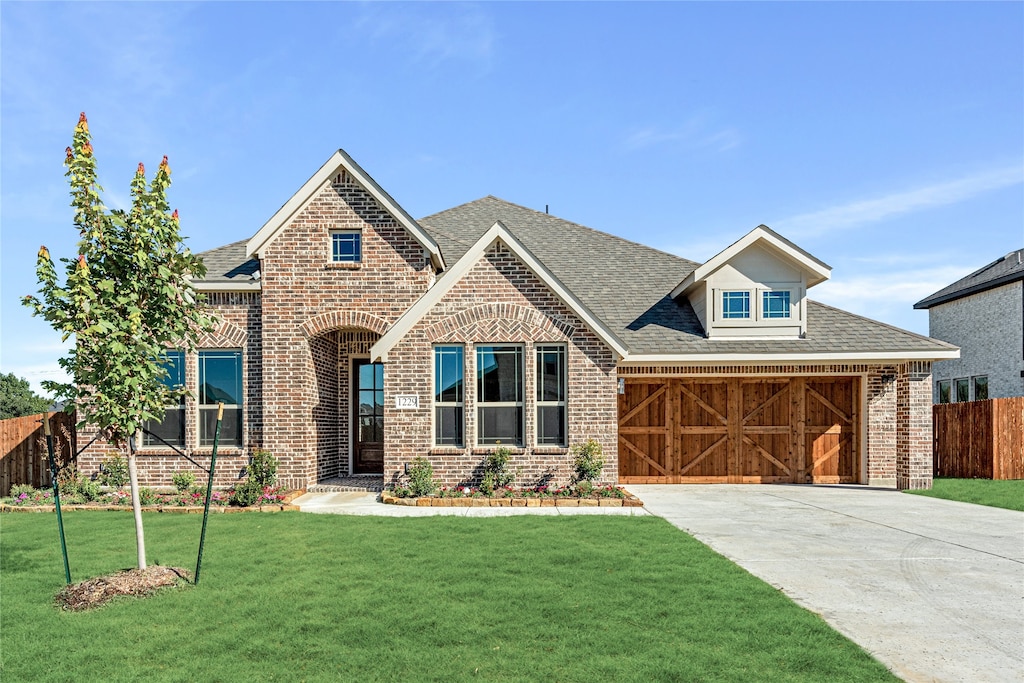 view of front of house featuring a garage and a front lawn