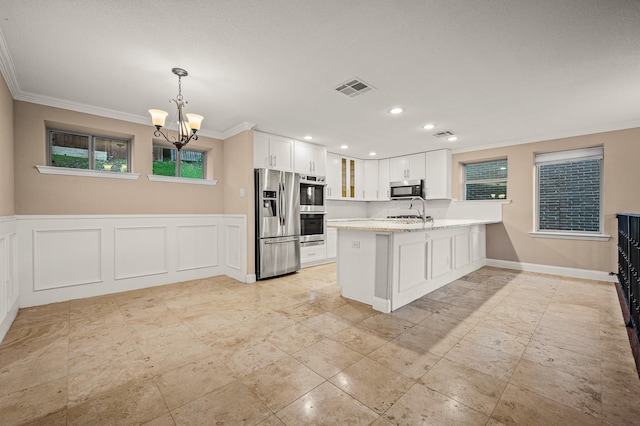 kitchen featuring kitchen peninsula, stainless steel appliances, pendant lighting, a notable chandelier, and white cabinetry