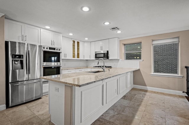 kitchen featuring light stone countertops, sink, kitchen peninsula, white cabinets, and appliances with stainless steel finishes