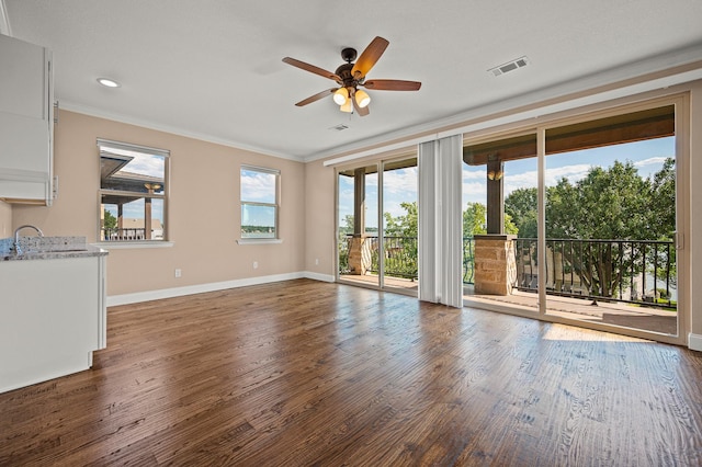 unfurnished living room featuring ceiling fan, dark hardwood / wood-style floors, and ornamental molding