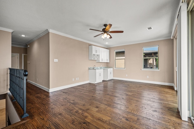 unfurnished living room featuring dark hardwood / wood-style flooring, ceiling fan, and crown molding