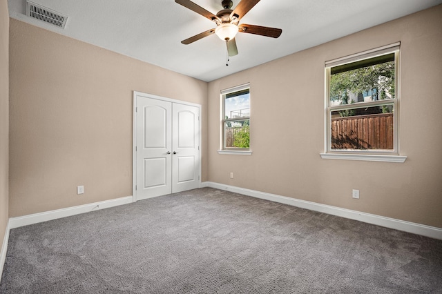 unfurnished bedroom featuring carpet, ceiling fan, and a closet