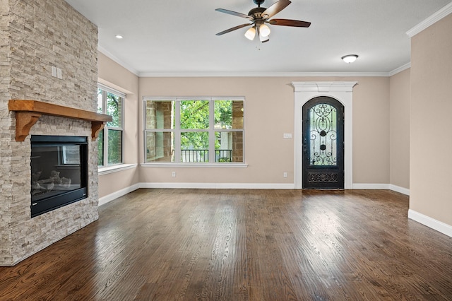 foyer entrance with ceiling fan, dark hardwood / wood-style flooring, ornamental molding, and a fireplace