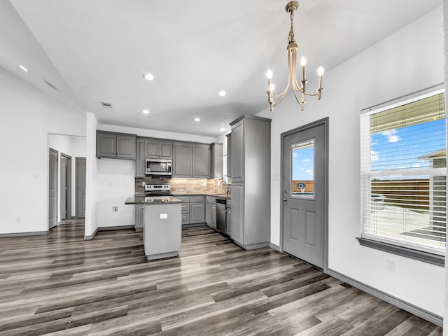 kitchen featuring dark hardwood / wood-style flooring, stainless steel appliances, gray cabinetry, tasteful backsplash, and sink