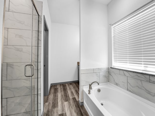 bathroom featuring wood-type flooring and separate shower and tub