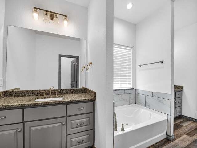 bathroom with vanity, a tub, and hardwood / wood-style floors