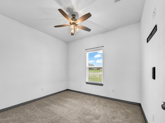 carpeted spare room with ceiling fan