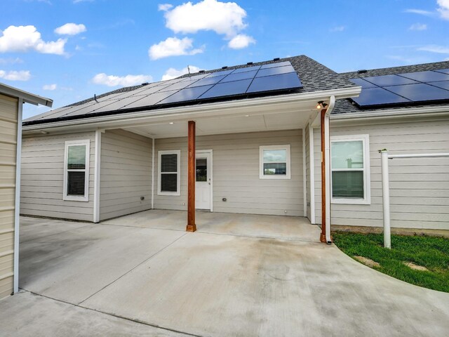 back of property featuring a patio and solar panels