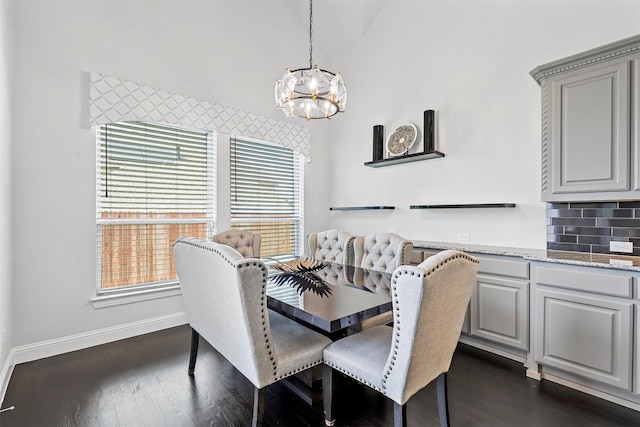 dining room with dark wood-style floors, baseboards, and an inviting chandelier