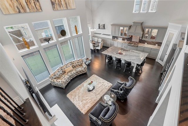 living room featuring a high ceiling and dark wood-style flooring