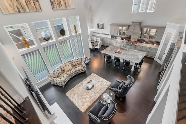 living room with a towering ceiling and dark hardwood / wood-style floors