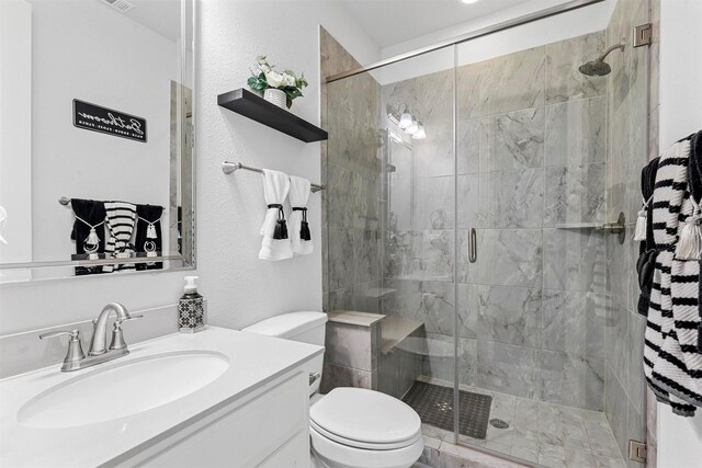 bathroom featuring vanity, toilet, and an enclosed shower