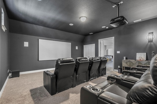 home theater room featuring carpet floors, a textured ceiling, and visible vents
