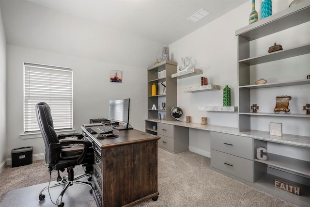 office area with visible vents, baseboards, and light carpet