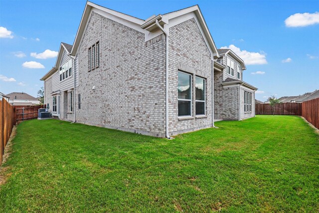 view of side of property featuring a lawn and central air condition unit