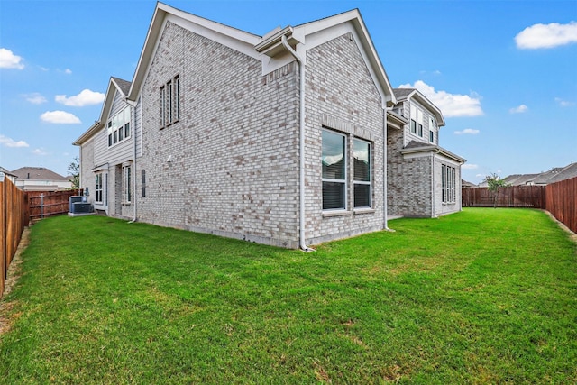 view of property exterior featuring a fenced backyard, brick siding, a yard, and cooling unit