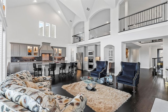 living room with high vaulted ceiling, dark wood-style floors, and recessed lighting