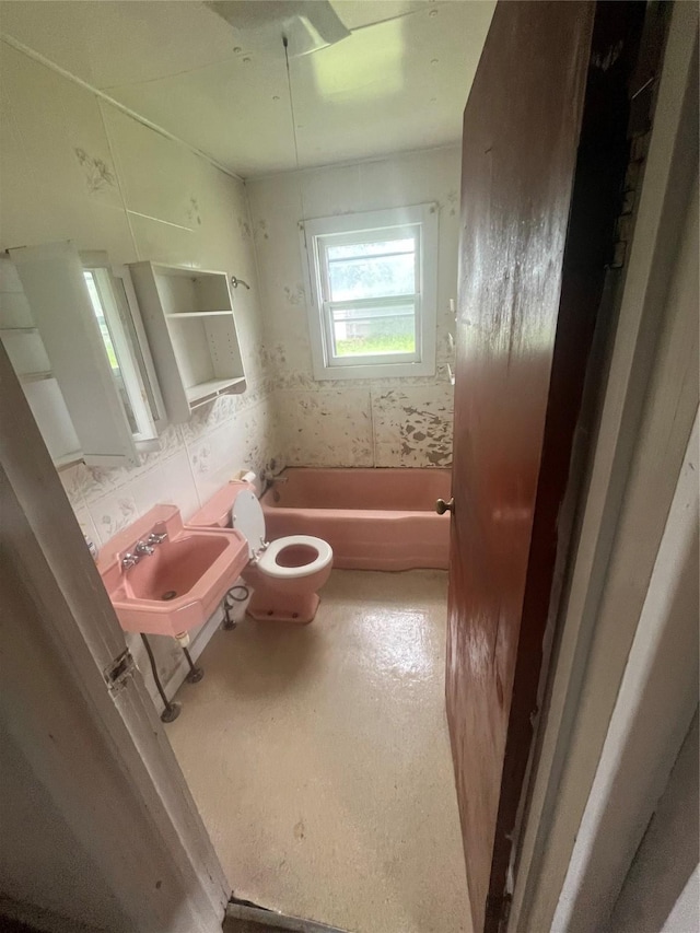 bathroom with toilet, sink, and tasteful backsplash