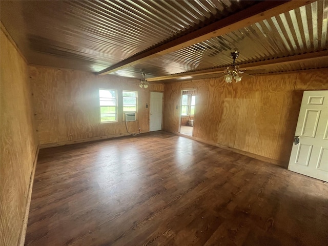 spare room featuring wooden walls, plenty of natural light, beamed ceiling, and ceiling fan