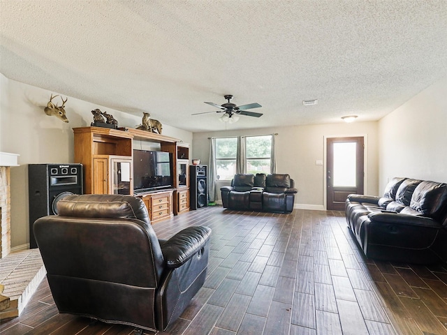 living room with dark hardwood / wood-style floors, ceiling fan, and a textured ceiling