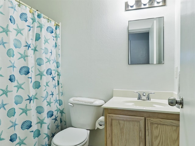 bathroom with vanity, curtained shower, and toilet