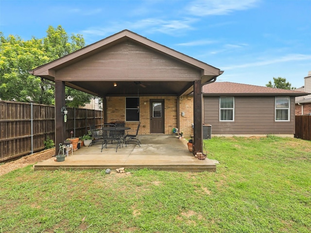 rear view of property with a lawn and a patio