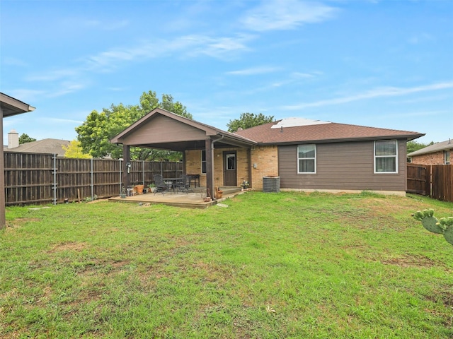 rear view of property featuring central air condition unit, a patio area, and a yard