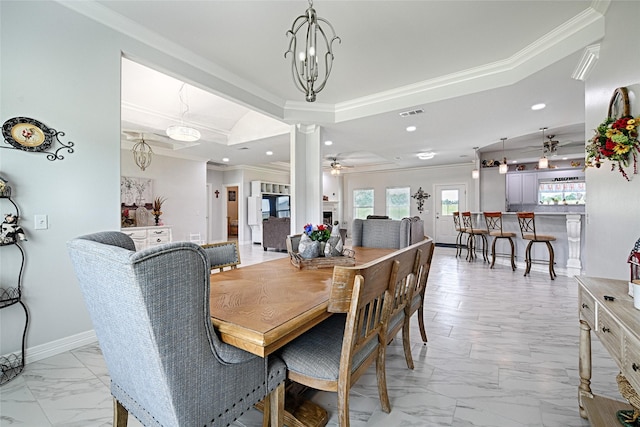 dining area with ceiling fan with notable chandelier, decorative columns, and ornamental molding