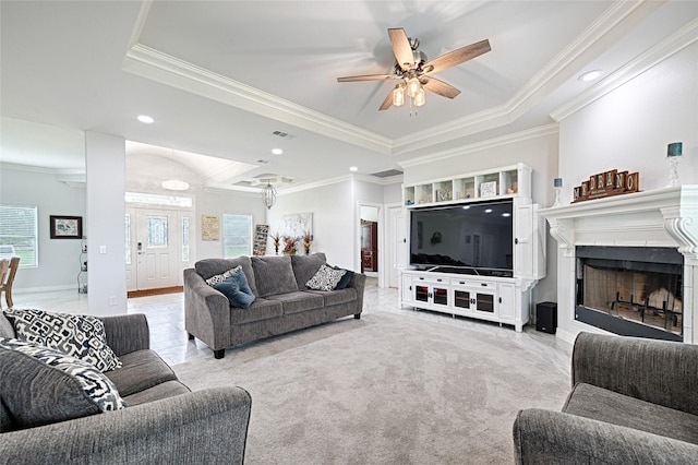 living room with light carpet, a tray ceiling, ceiling fan, and ornamental molding