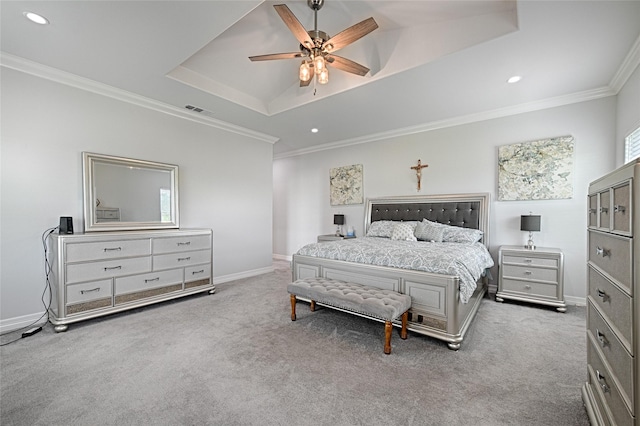 carpeted bedroom featuring a tray ceiling, ceiling fan, and crown molding