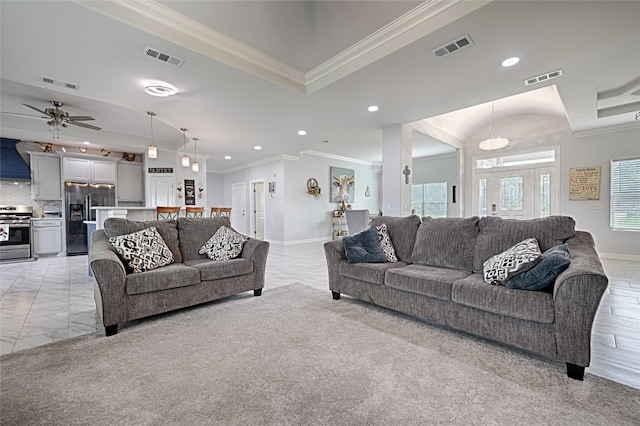 living room featuring ceiling fan, light colored carpet, and ornamental molding