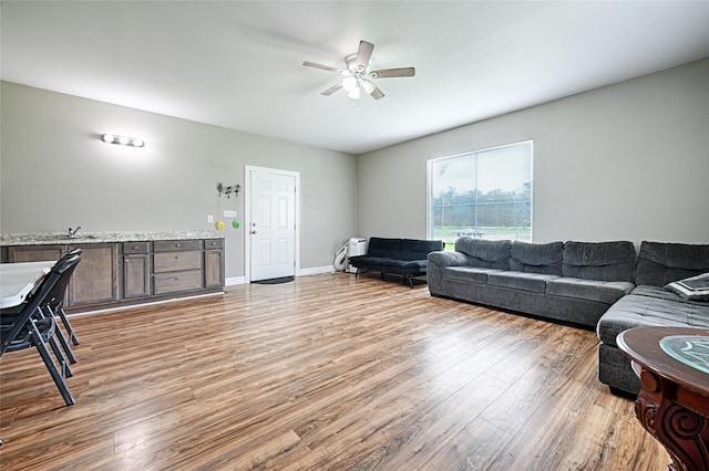 living room with light hardwood / wood-style floors and ceiling fan