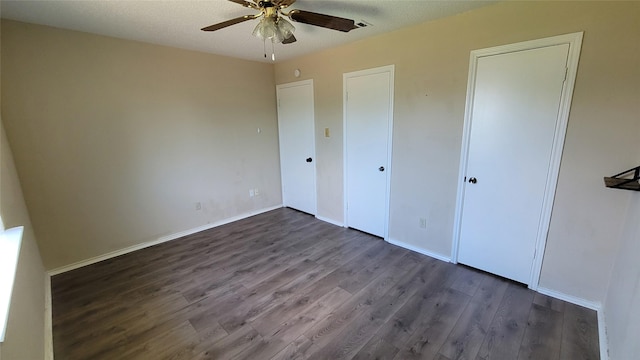 unfurnished bedroom with dark hardwood / wood-style flooring and ceiling fan