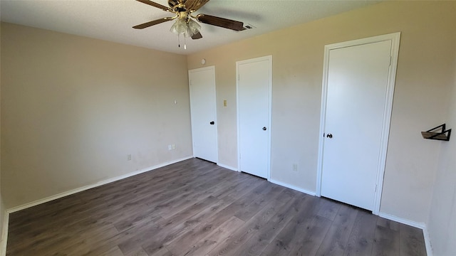 unfurnished bedroom featuring dark hardwood / wood-style floors and ceiling fan