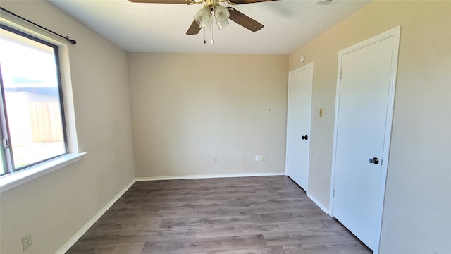 spare room with a textured ceiling, plenty of natural light, ceiling fan, and hardwood / wood-style floors