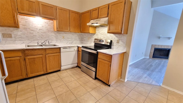 kitchen with sink, tasteful backsplash, light tile patterned floors, white dishwasher, and electric stove