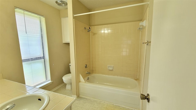 full bathroom with tiled shower / bath combo, vanity, a textured ceiling, tile patterned floors, and toilet