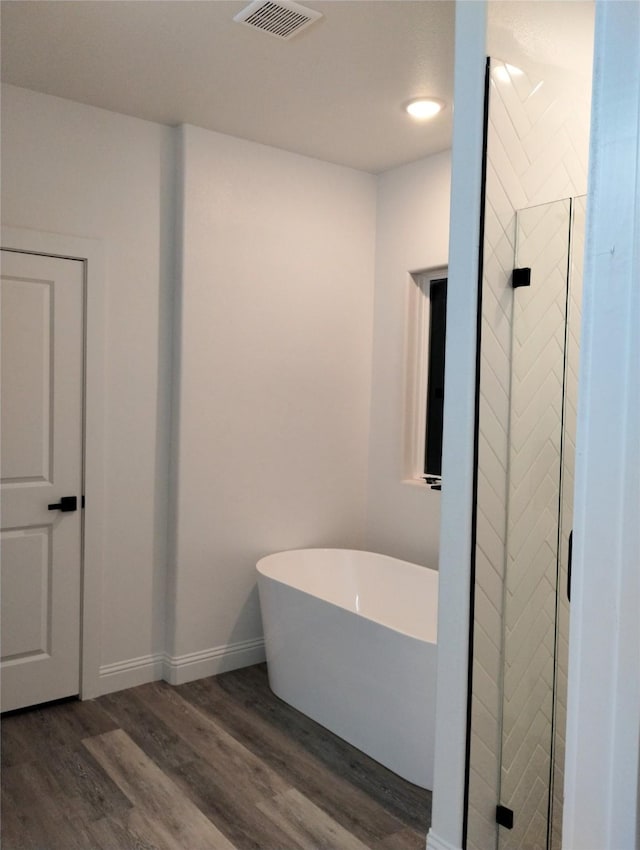 bathroom featuring hardwood / wood-style flooring and shower with separate bathtub