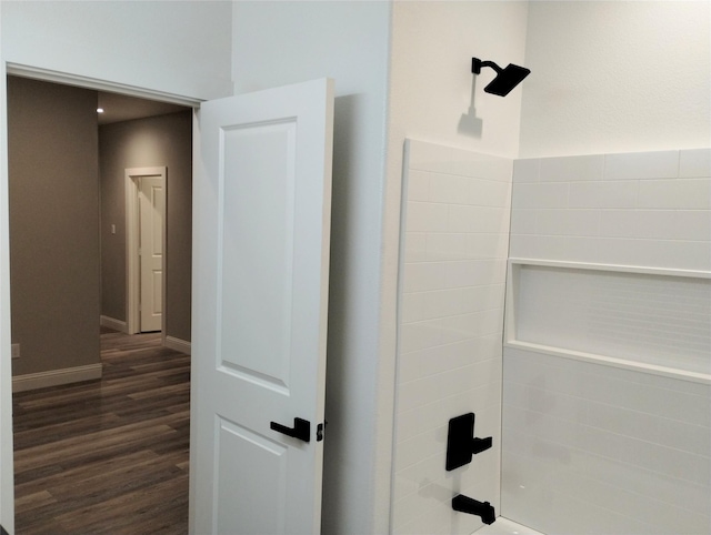 bathroom featuring hardwood / wood-style floors and  shower combination