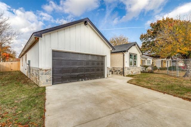 view of front of home featuring stone siding, board and batten siding, a front lawn, and fence