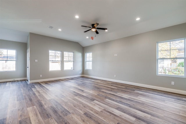 empty room with light hardwood / wood-style flooring, ceiling fan, and vaulted ceiling