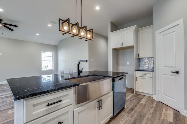 kitchen featuring white cabinetry, dark stone countertops, dishwasher, pendant lighting, and a kitchen island with sink